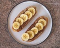 Two peanut butter and banana sandwiches, a healthy snack on a round plate, close-up diagonally Royalty Free Stock Photo