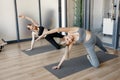 Two pregnant sporty women practice yoga in light gym