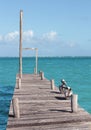 Two pelicans sit on a pier on the Caribbean Sea.