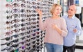 Two pensioners choosing sunglasses Royalty Free Stock Photo