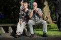 Two pensioners at a minigolf court are waiting on a park bench a