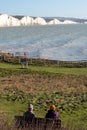 Two people admiring the view of Seven Sisters chalk cliffs at Hope Gap, Seaford, East Sussex on the south coast of England UK. Royalty Free Stock Photo