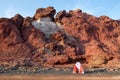 Two people camping in IranÃ¢â¬â¢s scenic Red Beach at Hormuz Island. Camper looks out from his open tent