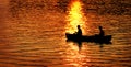 Two People in Canoe Fishing in Lake River at Sunset or Sunrise Royalty Free Stock Photo