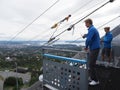 Two people care about zipline rider in european Oslo city seen from ski jump in Holmenkollen district in Norway