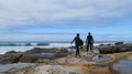 two people carrying boards walking on sandstone going for a surf Royalty Free Stock Photo