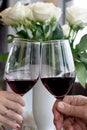 Two people clinking each other's glasses with red wine. Hand of young woman and old man Royalty Free Stock Photo