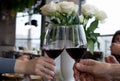 Two people clinking each others glasses with red wine. Hand of young woman and old man Royalty Free Stock Photo