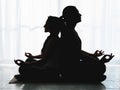 Two people are doing Yoga inside, they are in shadows Royalty Free Stock Photo