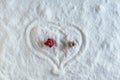 Two people dolls in winter clothes in the shape of heart on the snow. Aerial, top view. Concept of date valentine`s day