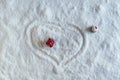 Two people dolls in winter clothes in the shape of heart on the snow. Aerial, top view. Concept of date valentine`s day