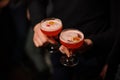 Two people holding cocktail glasses with sweet alcoholic drink Royalty Free Stock Photo