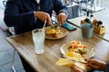 Two people eating breakfast dishes, Classic french toast with cheese and ham, and Avocado toast with soft boiled eggs Royalty Free Stock Photo