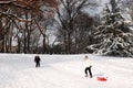 Two people enjoy winter sledding