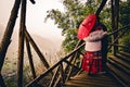 Two people enjoying the landscape view with a traditional paper umbrella on a wooden staircase in Sapa. Sapa, Vietnam - 01/02/