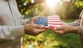 Hands holding American flag outdoors Royalty Free Stock Photo