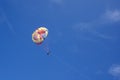 Two people glide with a parachute against the blue sky. Selective focus Royalty Free Stock Photo