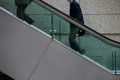 Two people going up escalator