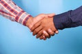 two people hand shake against blue background, Royalty Free Stock Photo