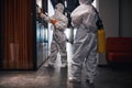 Two people in hazmat suits disinfecting the office corridor Royalty Free Stock Photo