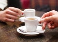 Two people holding cups of coffee sitting in cafeteria. Royalty Free Stock Photo