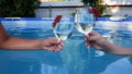 two people are holding glasses with alcoholic refreshing summer cocktail close-up on the background of the pool. the Royalty Free Stock Photo