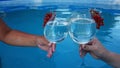 two people are holding glasses with alcoholic refreshing summer cocktail close-up on the background of the pool. the Royalty Free Stock Photo