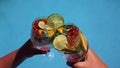 two people are holding a summer refreshing drink in a glass against the background of water. Royalty Free Stock Photo