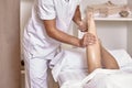 Two people, man physiotherapist leg massage, hands close up. Royalty Free Stock Photo