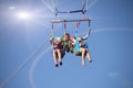 two people parasailing on beach in summer. Happy couple kissing under parachute in air above surface of the sea Royalty Free Stock Photo