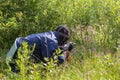 Two people playing airsoft hid in ambush behind fence