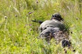 Two people playing airsoft hid in ambush behind fence