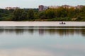 Two people in a pond on the background of the banks of the city with houses Royalty Free Stock Photo