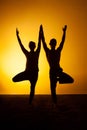 Two people practicing yoga in the sunset light Royalty Free Stock Photo