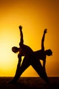 Two people practicing yoga in the sunset light Royalty Free Stock Photo