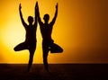 Two people practicing yoga in the sunset light Royalty Free Stock Photo