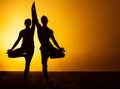 Two people practicing yoga in the sunset light Royalty Free Stock Photo