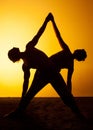 Two people practicing yoga in the sunset light Royalty Free Stock Photo