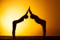 Two people practicing yoga in the sunset light Royalty Free Stock Photo