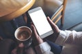 Two people`s hands holding white mobile phone with blank desktop screen and a coffee cup Royalty Free Stock Photo