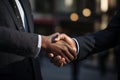 Two people shake hands with an office building background, business meeting image Royalty Free Stock Photo