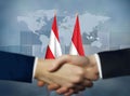 Two people shaking hands in front of Indonesia and Austria flags Royalty Free Stock Photo