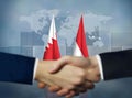 Two people shaking hands in front of Indonesia and Bahrain flags Royalty Free Stock Photo