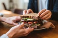 two people sharing a rye bread sandwich Royalty Free Stock Photo