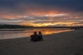 Two people are sitting on the bank