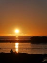 Two people sitting on beach as the sun sets, Essaouira, Morocco Royalty Free Stock Photo