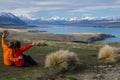 Two people sitting and looking at Lake tekapo from Mount John observatory, South Island, New Zealand