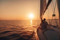 two people sitting on a sailboat in the ocean at sunset Royalty Free Stock Photo