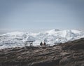 Two people sitting with view towards Icefjord in Ilulissat. Easy hiking route to the famous Kangia glacier in Greenland