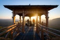 Two people standing in the gazebo during a beautiful sunset.